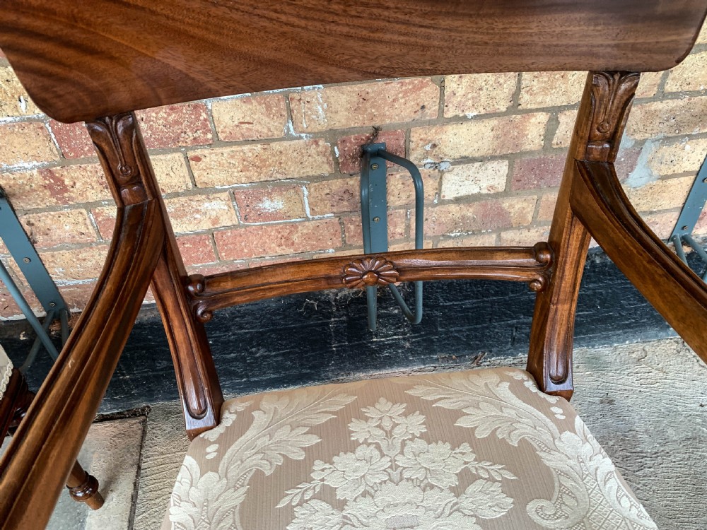 A set of eight Victorian mahogany dining chairs featuring curved top rails and patterned upholstered seats arranged in rows. View XIV