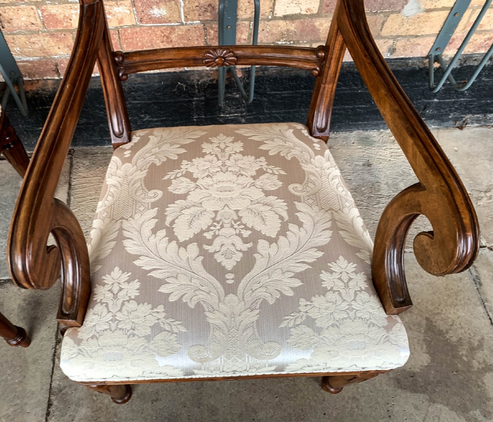 A set of eight Victorian mahogany dining chairs featuring curved top rails and patterned upholstered seats arranged in rows. View XV