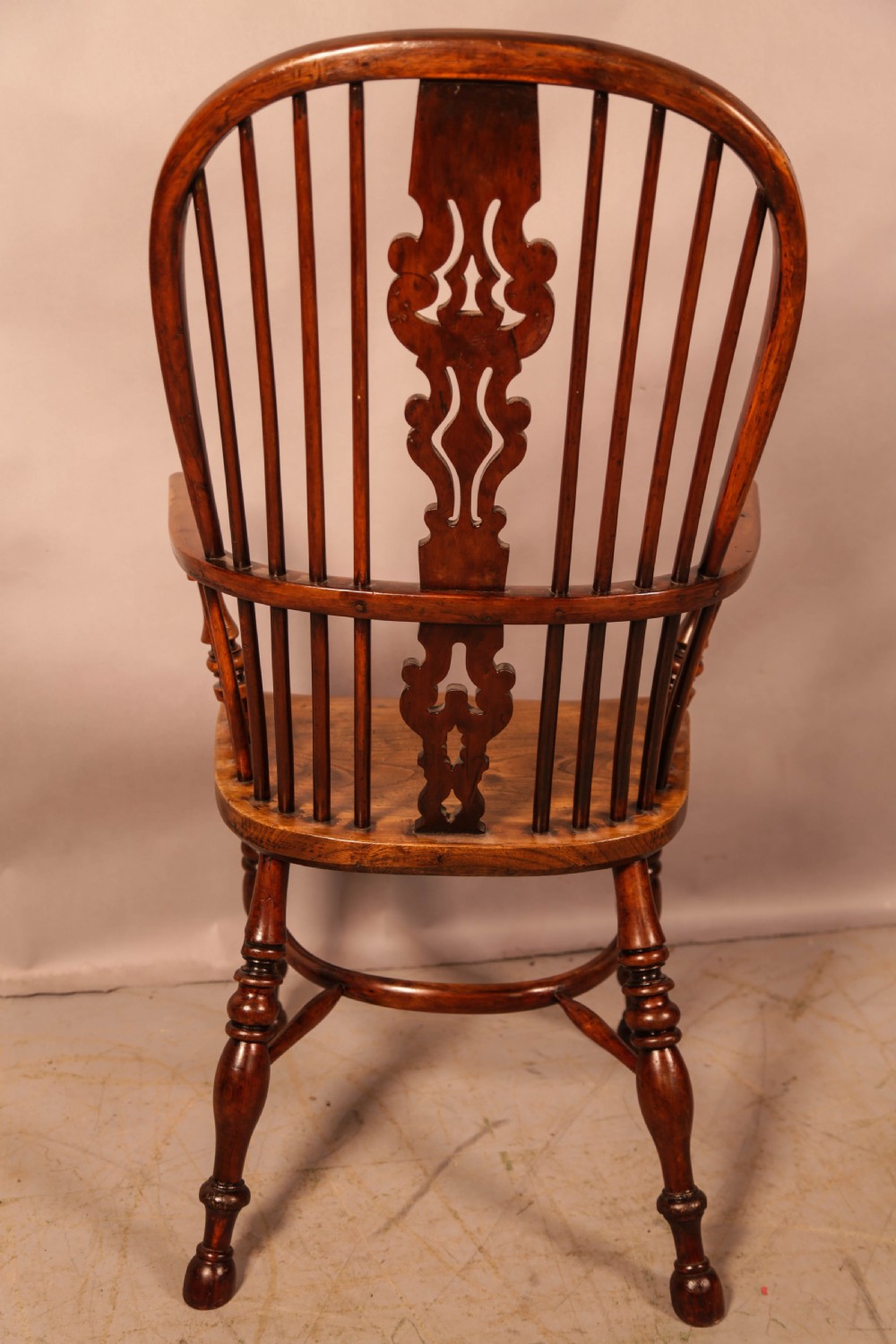 An antique yew wood Windsor armchair featuring a pierced back splat, spindle backrest, turned legs, and a crinoline stretcher. View II