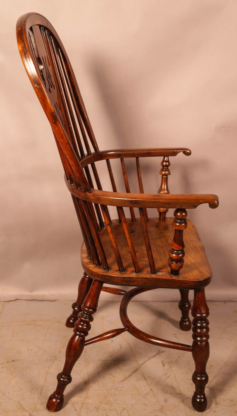 An antique yew wood Windsor armchair featuring a pierced back splat, spindle backrest, turned legs, and a crinoline stretcher. View III