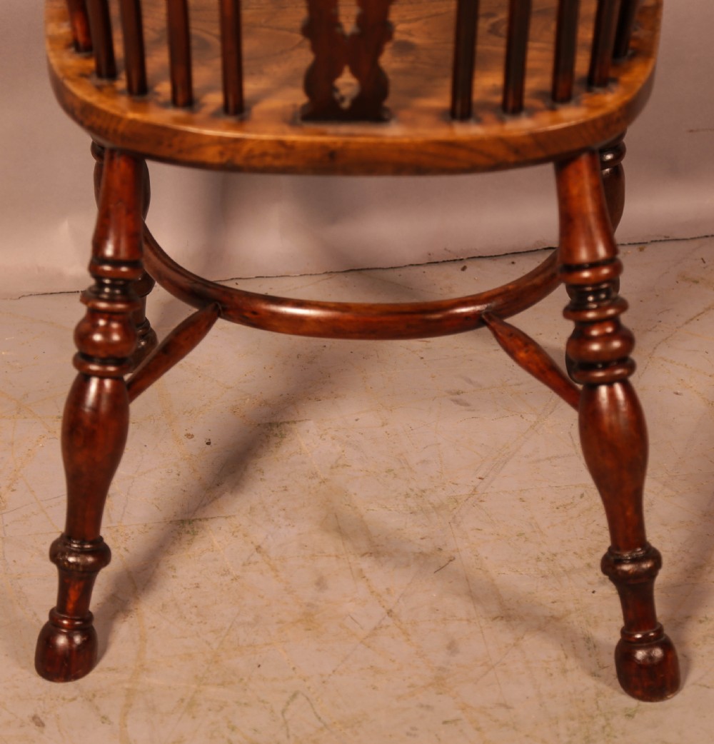 An antique yew wood Windsor armchair featuring a pierced back splat, spindle backrest, turned legs, and a crinoline stretcher. View IV