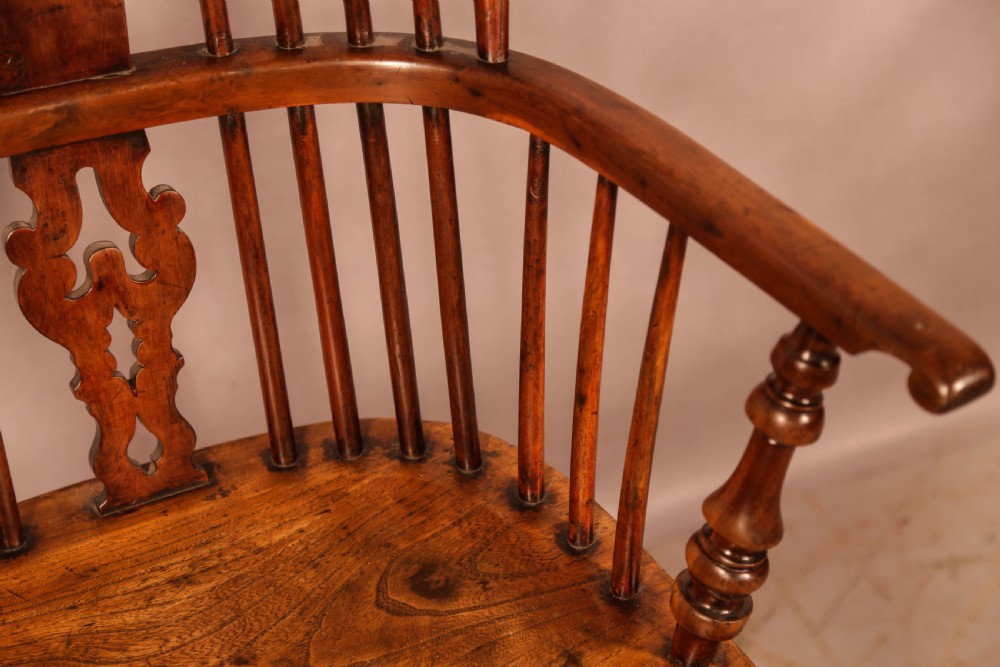 An antique yew wood Windsor armchair featuring a pierced back splat, spindle backrest, turned legs, and a crinoline stretcher. View IX