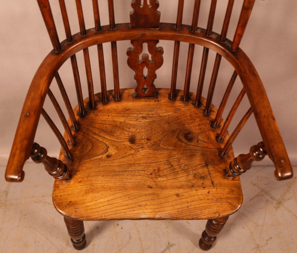 An antique yew wood Windsor armchair featuring a pierced back splat, spindle backrest, turned legs, and a crinoline stretcher. View XII