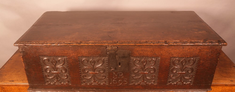 A 17th-century carved dark oak document box with an iron latch, carved initials MB, and date 1695 on the front panel. View IV