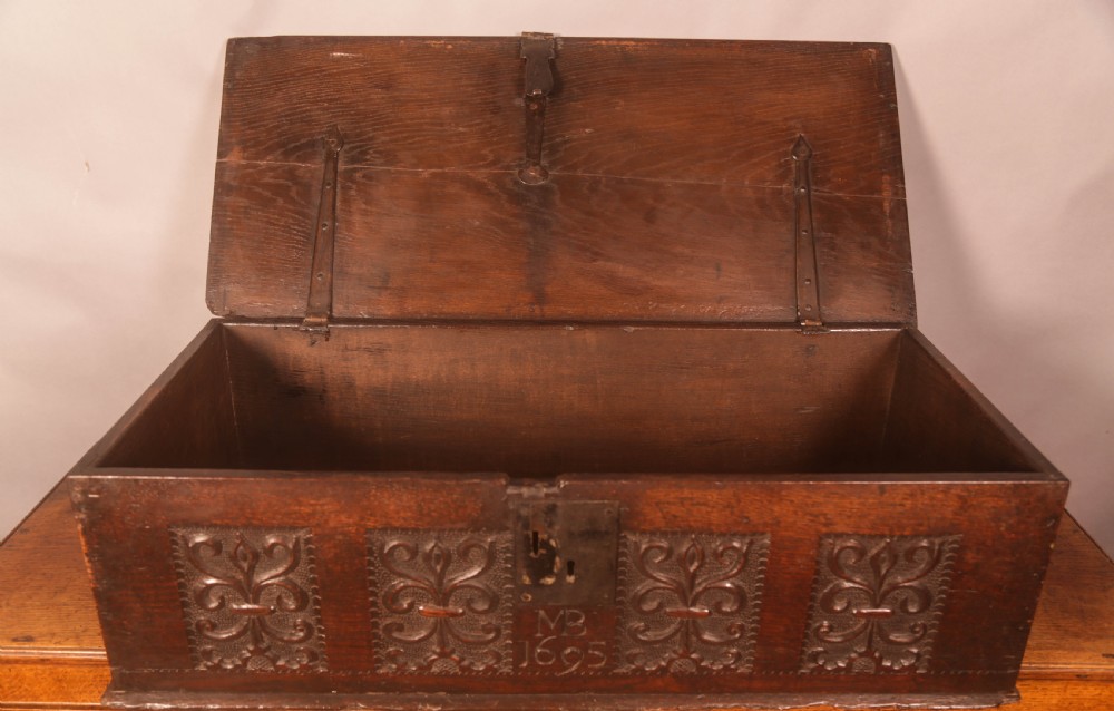 A 17th-century carved dark oak document box with an iron latch, carved initials MB, and date 1695 on the front panel. View VI