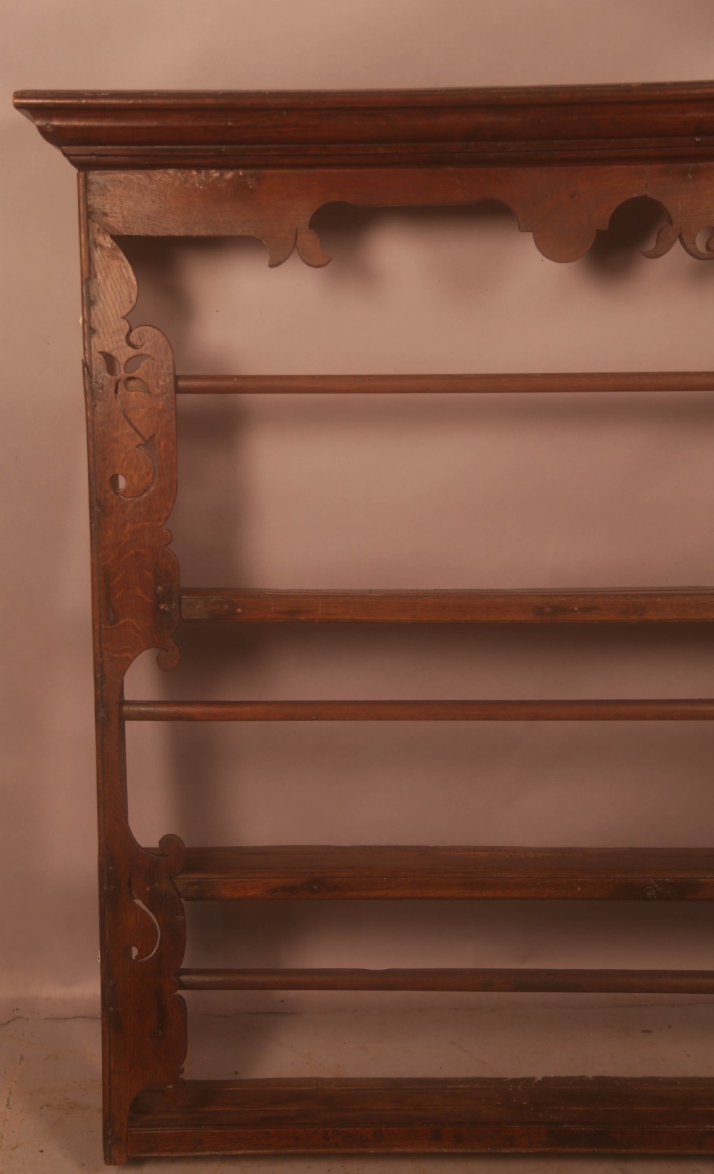 A Georgian dark oak wall-mounted plate rack featuring three horizontal shelves with retaining rails, a moulded top cornice, and decorative fretwork aprons. View II