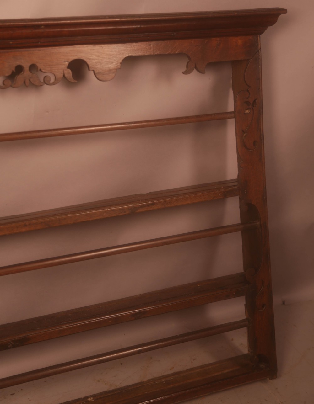 A Georgian dark oak wall-mounted plate rack featuring three horizontal shelves with retaining rails, a moulded top cornice, and decorative fretwork aprons. View VII