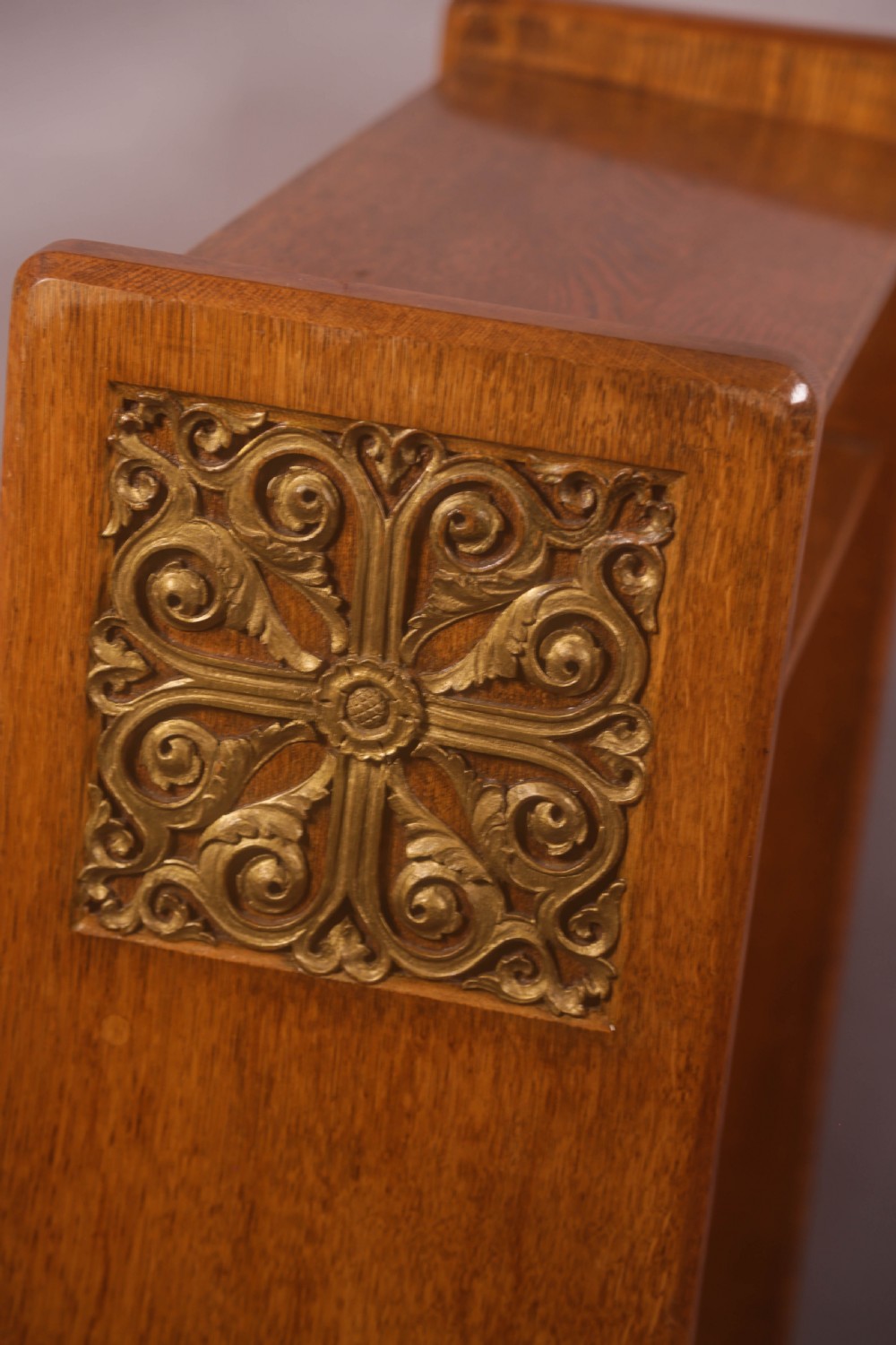 A late Victorian oak reading stand featuring recessed side panels and a decorative cast brass frieze with a central cherub motif. View III