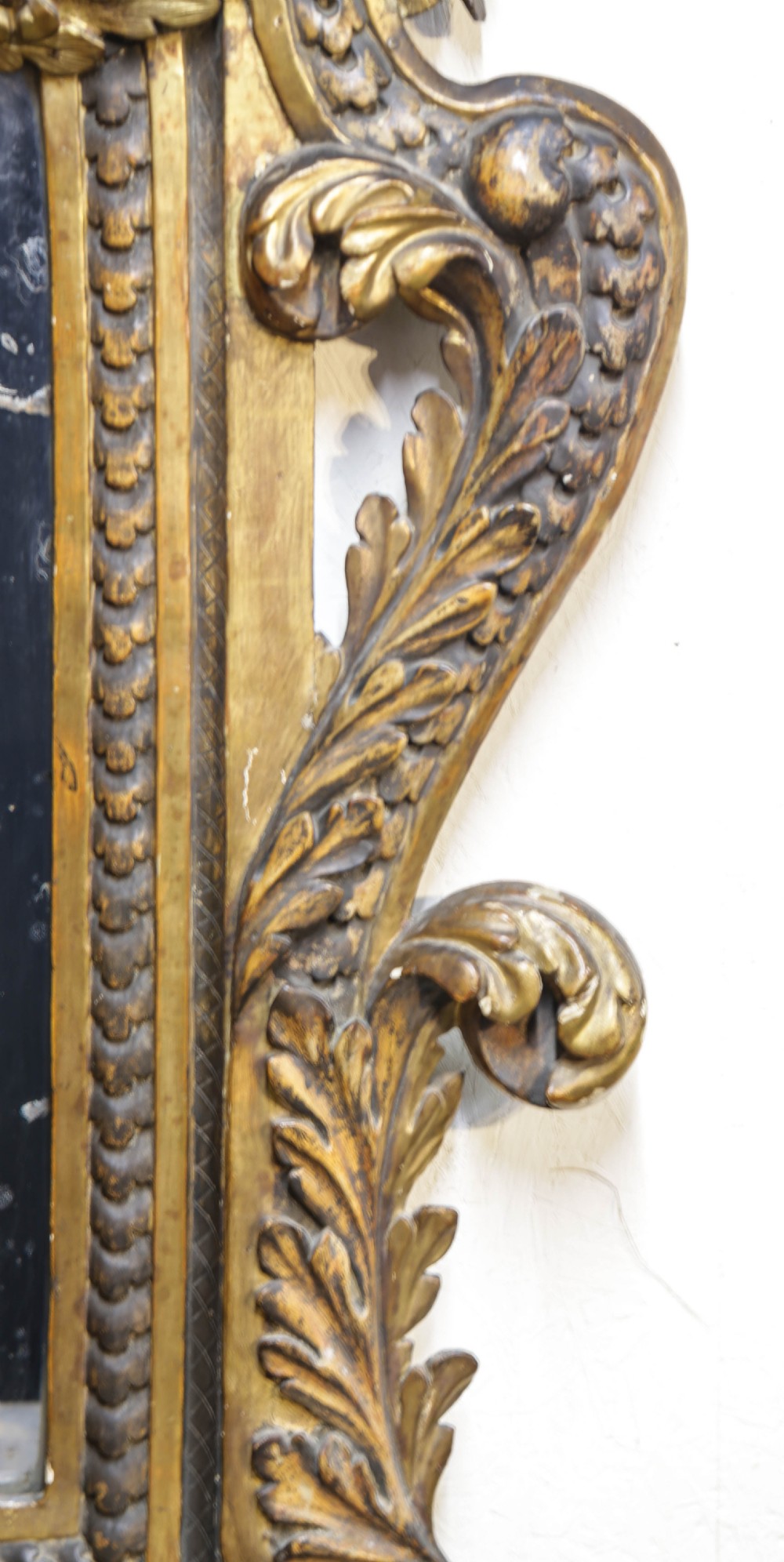 An 18th century Italian console table and matching mirror featuring heavily carved giltwood, putti supports, and ornate floral motifs. View XVI