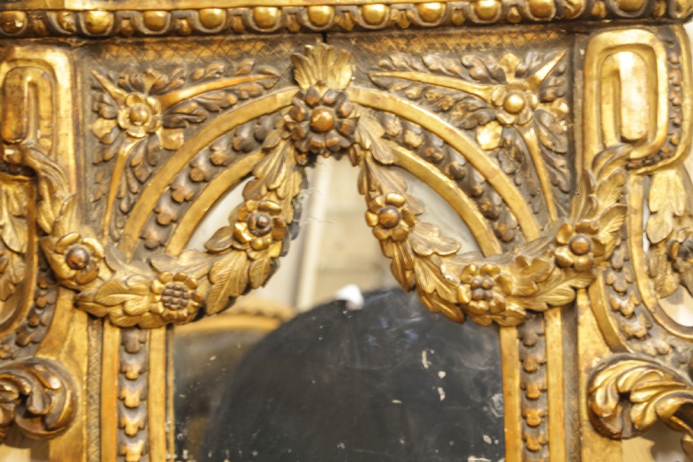 An 18th century Italian console table and matching mirror featuring heavily carved giltwood, putti supports, and ornate floral motifs. View XVII