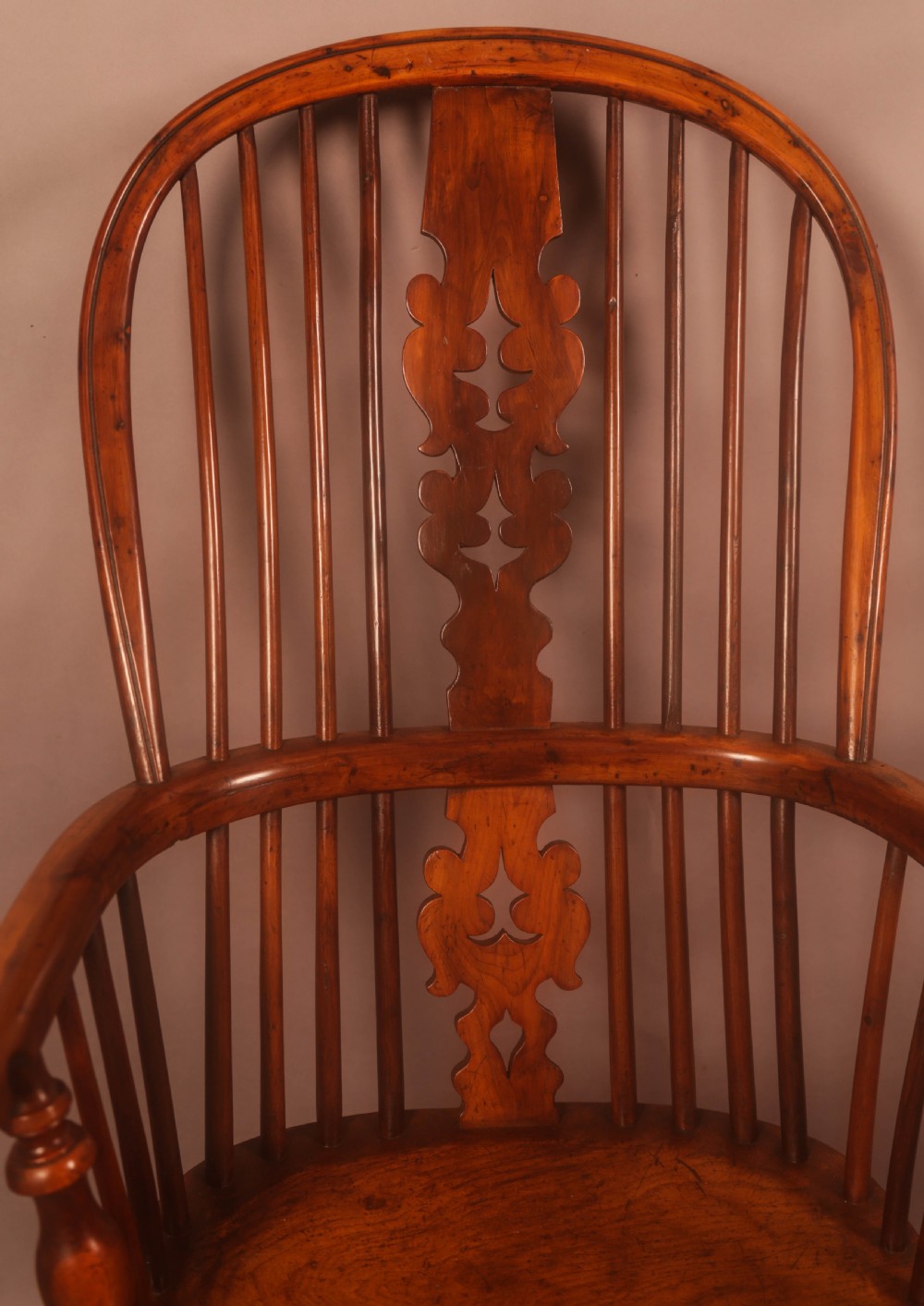 A high-backed antique wooden Windsor armchair featuring a central pierced splat, numerous spindles, sculpted armrests, and turned legs. View VII