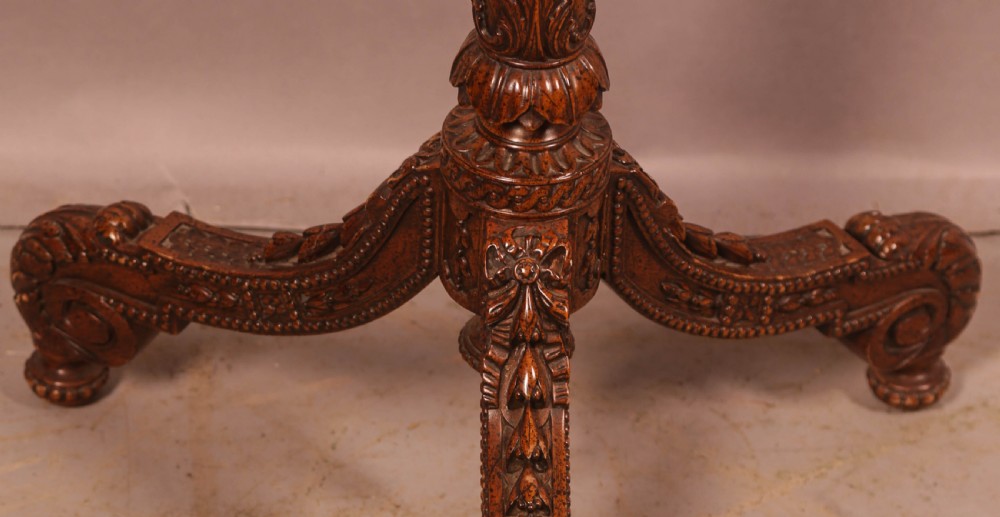 A nineteenth-century dark wood pole screen featuring an embroidered floral tapestry panel mounted on a brass rod with a heavily carved tripod base. View IV