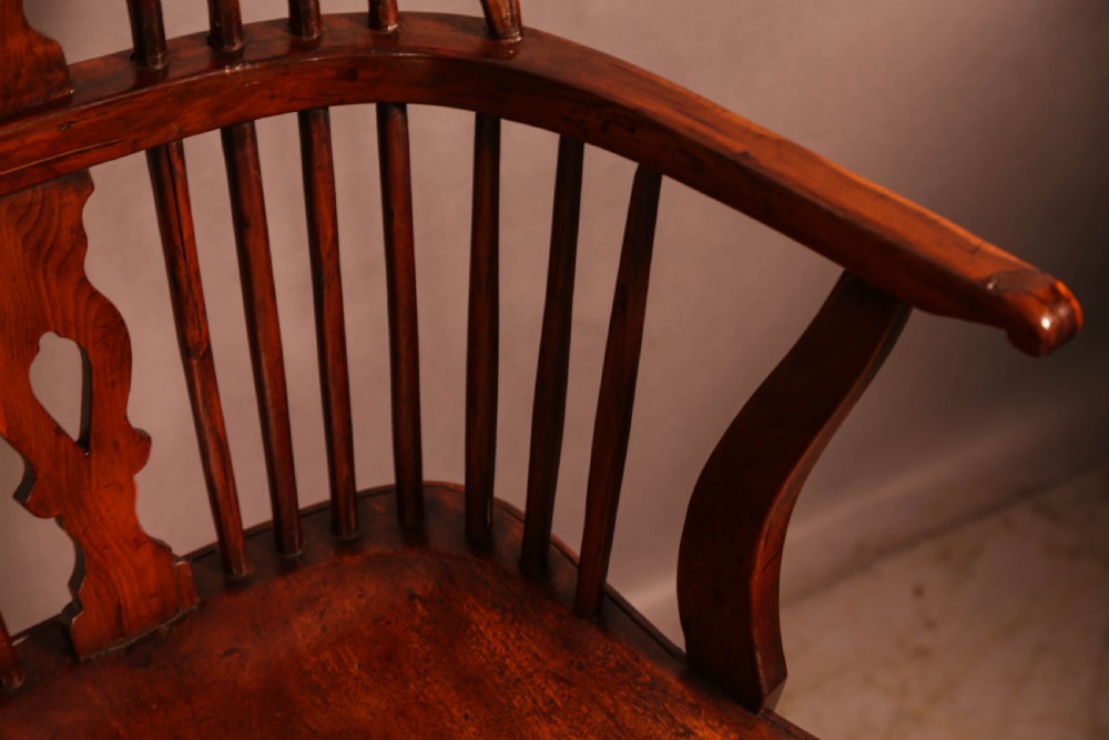 An English yew wood low-back Windsor armchair featuring a pierced splat, spindle back, shaped seat, turned legs, and a curved stretcher. View VI