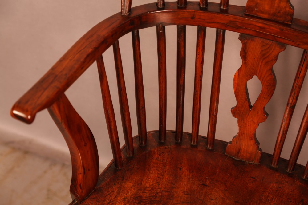 An English yew wood low-back Windsor armchair featuring a pierced splat, spindle back, shaped seat, turned legs, and a curved stretcher. View VII