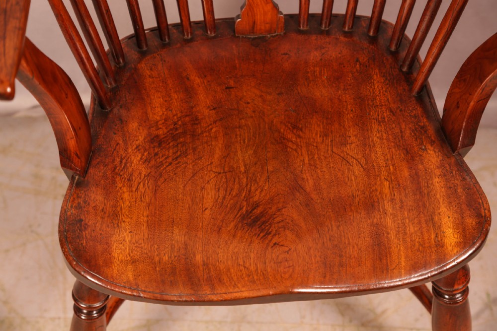 An English yew wood low-back Windsor armchair featuring a pierced splat, spindle back, shaped seat, turned legs, and a curved stretcher. View VIII
