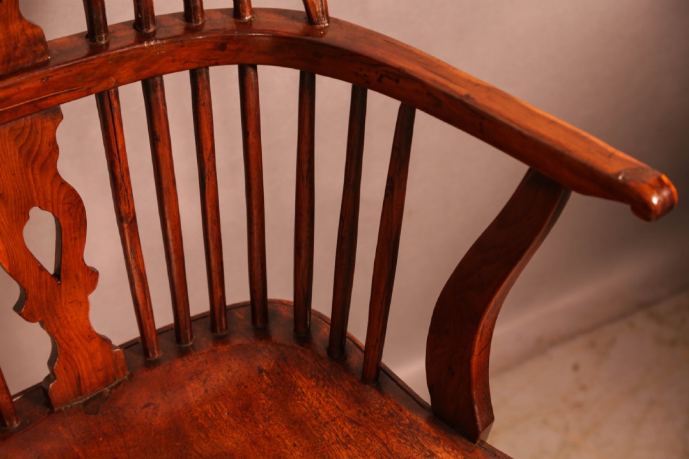 An English yew wood low-back Windsor armchair featuring a pierced splat, spindle back, shaped seat, turned legs, and a curved stretcher. View IX