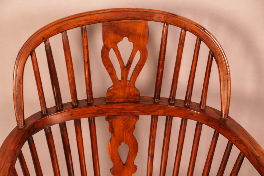 An English yew wood low-back Windsor armchair featuring a pierced splat, spindle back, shaped seat, turned legs, and a curved stretcher. View X