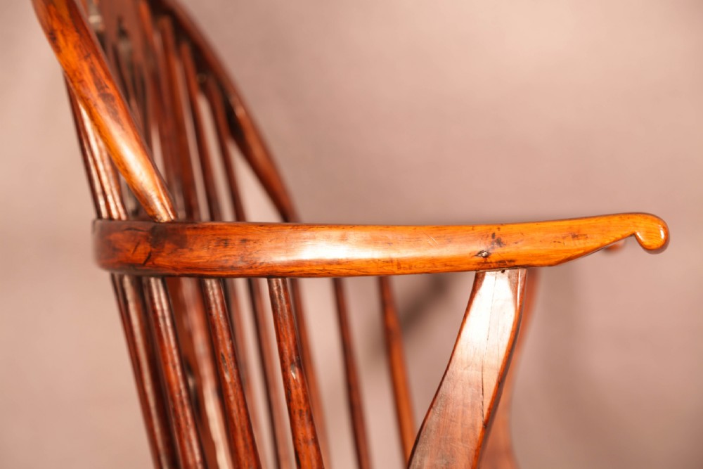 An English yew wood low-back Windsor armchair featuring a pierced splat, spindle back, shaped seat, turned legs, and a curved stretcher. View XII