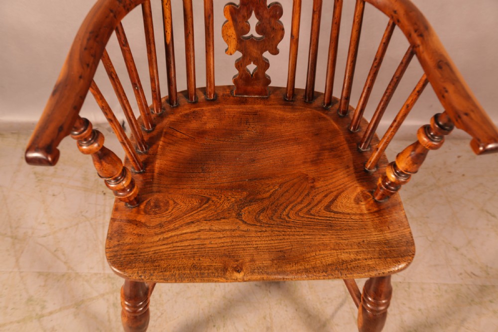 An antique yew wood high-back Windsor armchair featuring a pierced decorative splat, slender spindles, contoured seat, and turned legs with a curved stretcher. View IX