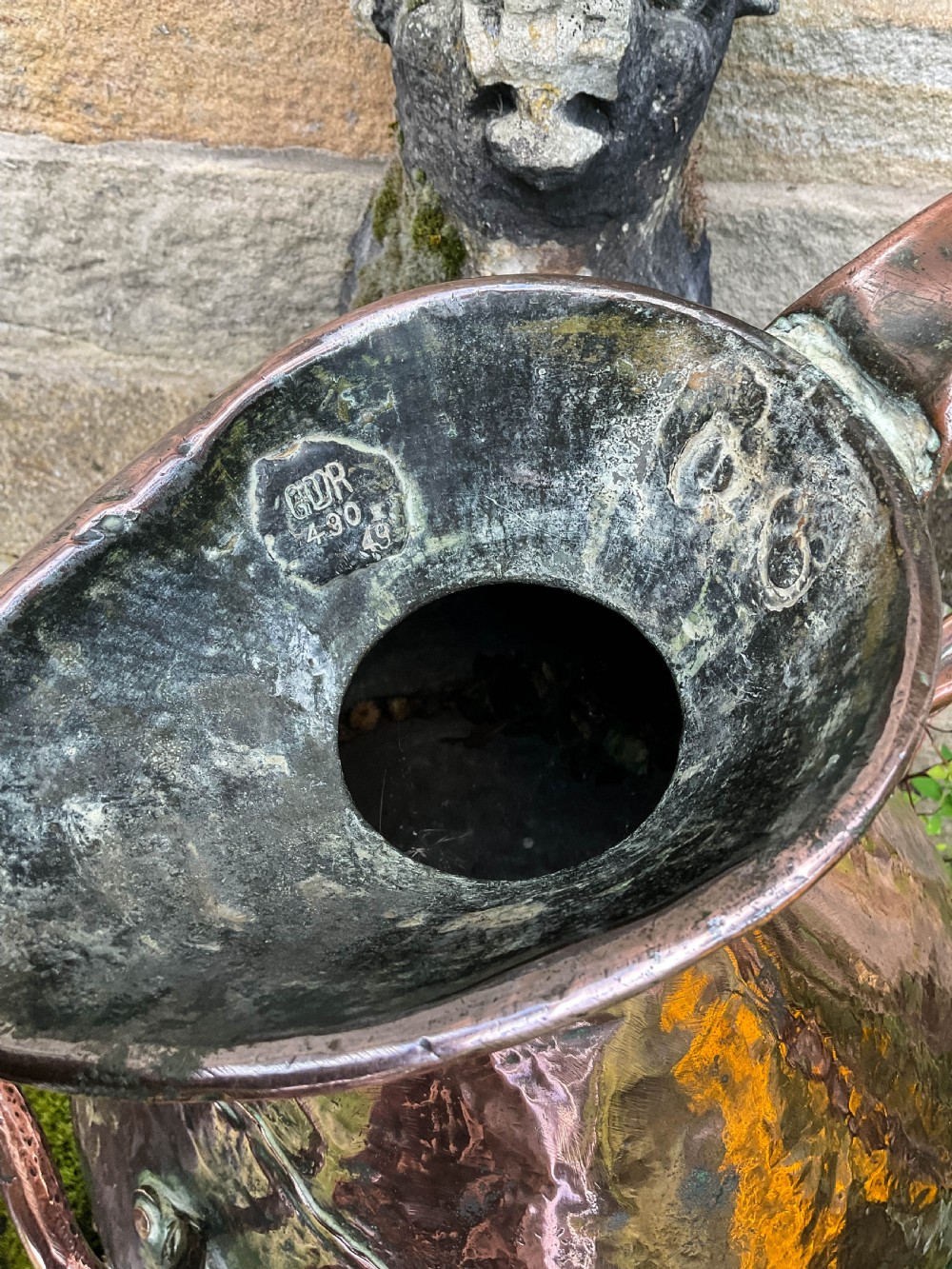 A collection of five graduated nineteenth-century copper harvest jugs featuring hand-beaten surfaces and looped handles. View II