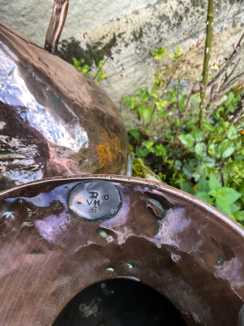 A collection of five graduated nineteenth-century copper harvest jugs featuring hand-beaten surfaces and looped handles. View III