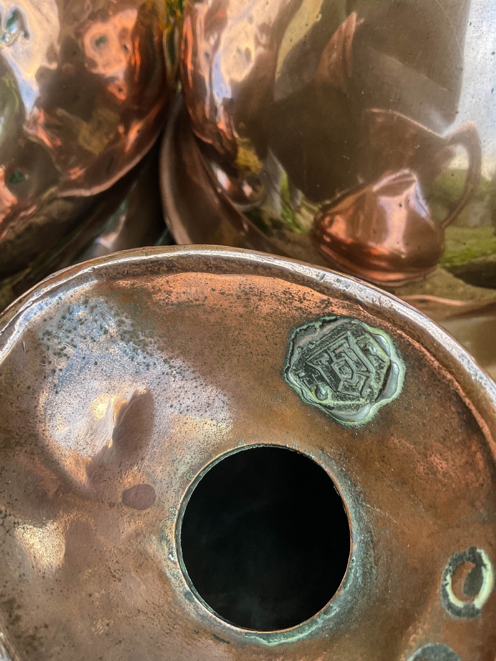 A collection of five graduated nineteenth-century copper harvest jugs featuring hand-beaten surfaces and looped handles. View IV
