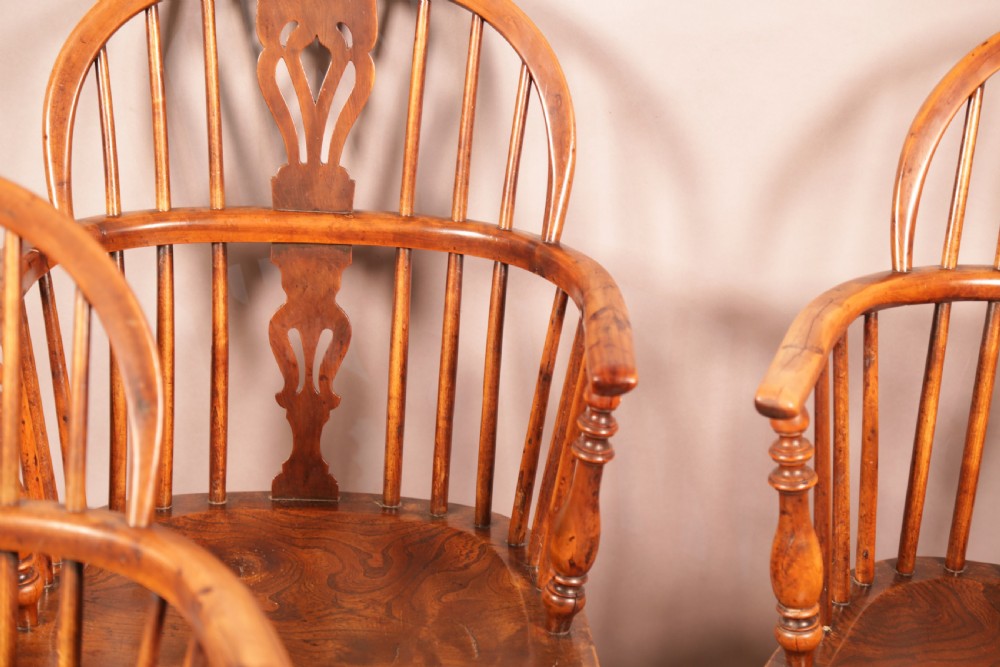 A matching set of four wooden Windsor armchairs featuring pierced splat backs, turned spindles, and sculpted seats. View III