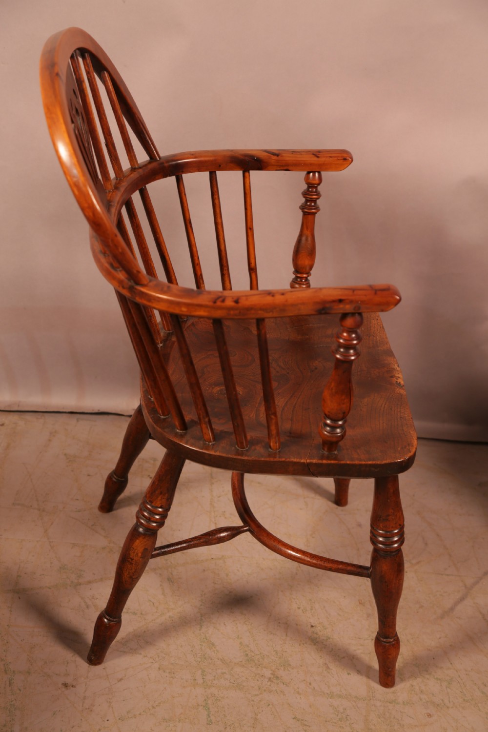 A matching set of four wooden Windsor armchairs featuring pierced splat backs, turned spindles, and sculpted seats. View VIII