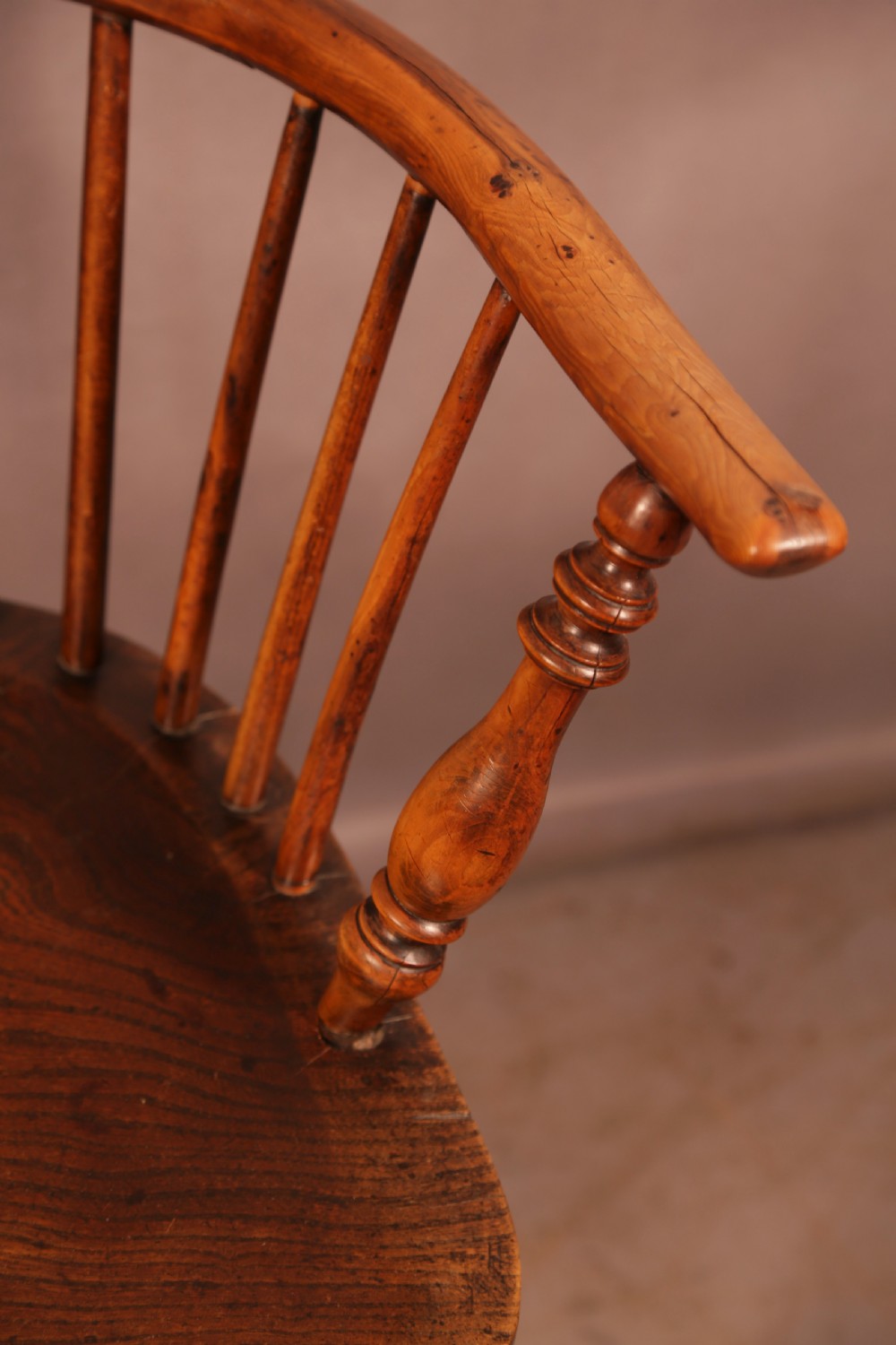 A matching set of four wooden Windsor armchairs featuring pierced splat backs, turned spindles, and sculpted seats. View XIII