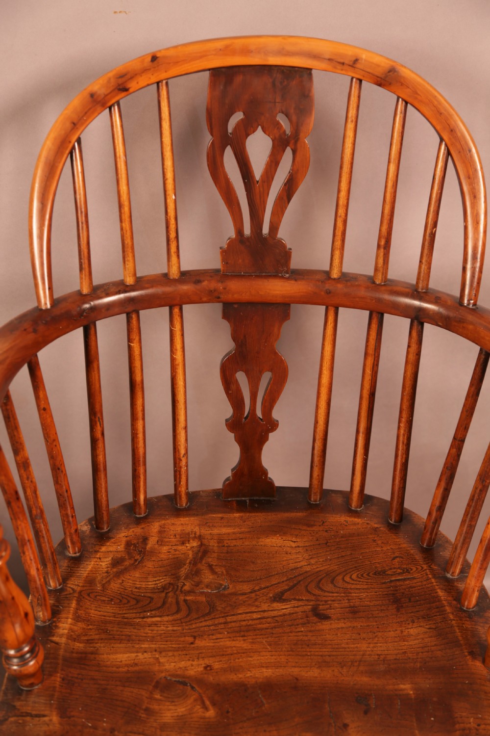 A matching set of four wooden Windsor armchairs featuring pierced splat backs, turned spindles, and sculpted seats. View XVI