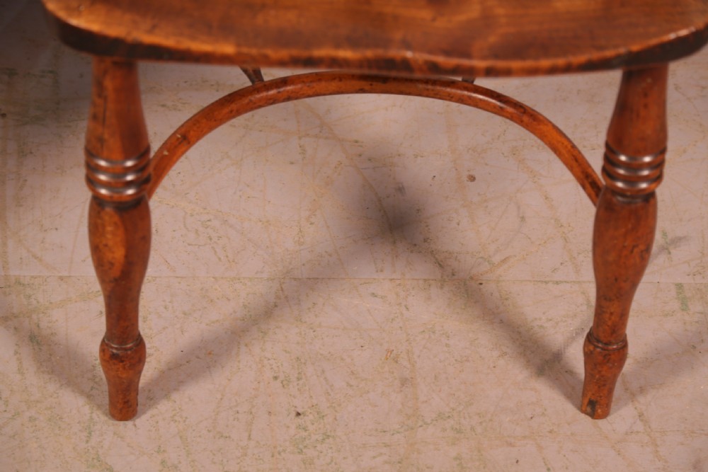 A matching set of four wooden Windsor armchairs featuring pierced splat backs, turned spindles, and sculpted seats. View XIX