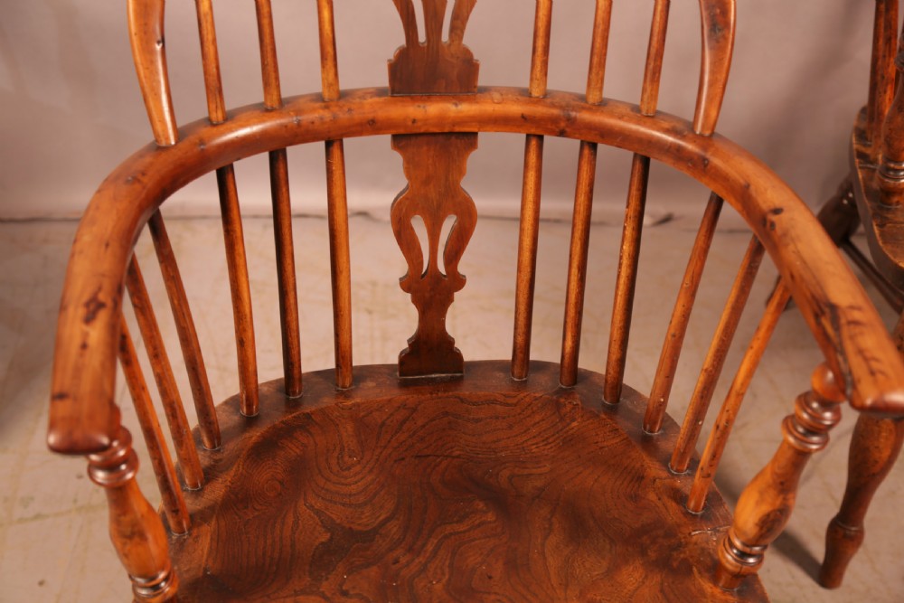 A matching set of four wooden Windsor armchairs featuring pierced splat backs, turned spindles, and sculpted seats. View XXII