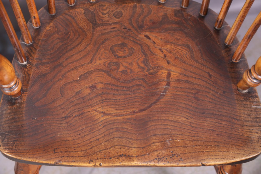 A matching set of four wooden Windsor armchairs featuring pierced splat backs, turned spindles, and sculpted seats. View XXVI