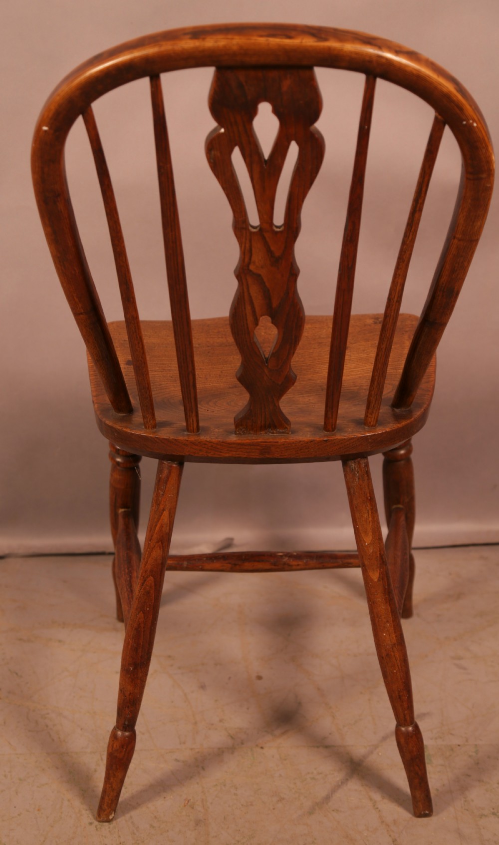 A matching set of four wooden Windsor chairs featuring shaped elm seats, stick-back spindles, and central pierced splats. View XI