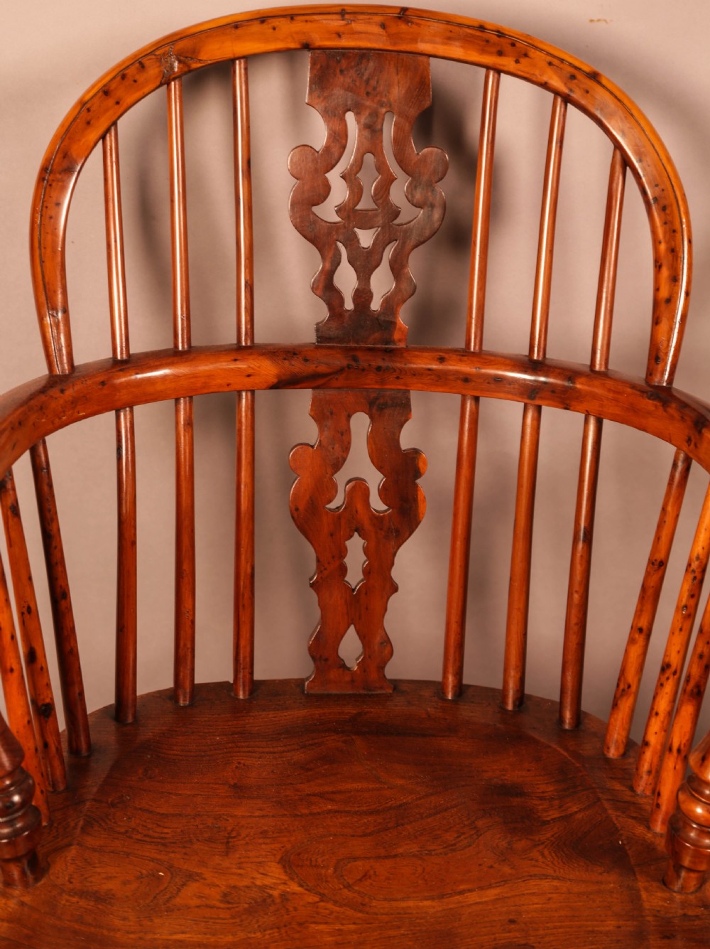 A pair of antique wooden Windsor armchairs featuring pierced splats, spindle backs, and turned legs with rich brown grain. View V
