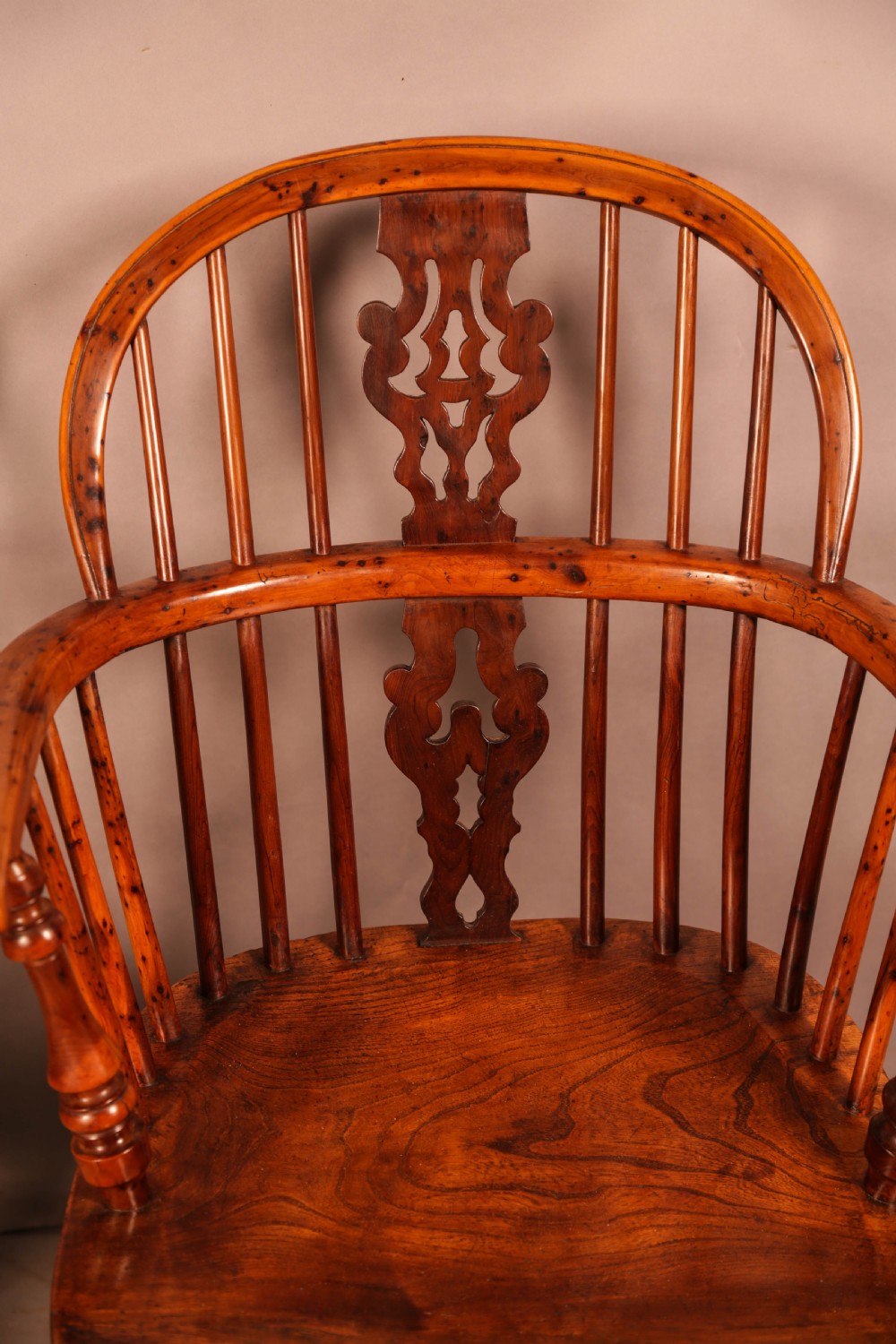 A pair of antique wooden Windsor armchairs featuring pierced splats, spindle backs, and turned legs with rich brown grain. View VI
