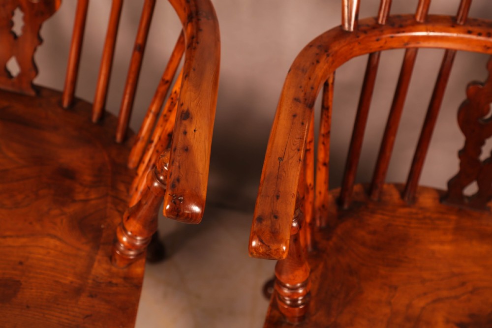 A pair of antique wooden Windsor armchairs featuring pierced splats, spindle backs, and turned legs with rich brown grain. View VII