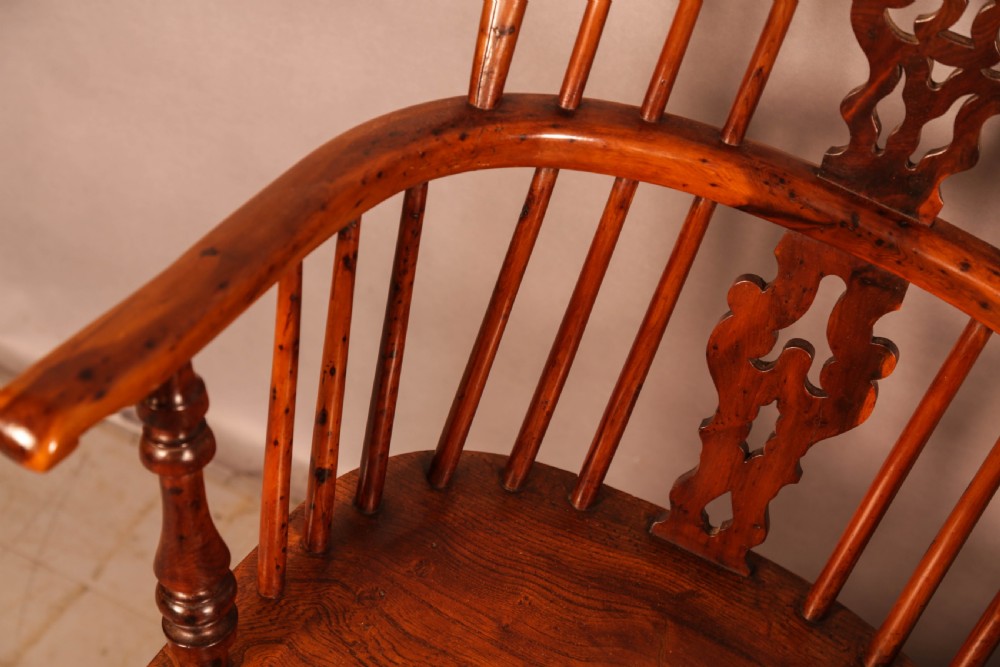 A pair of antique wooden Windsor armchairs featuring pierced splats, spindle backs, and turned legs with rich brown grain. View VIII