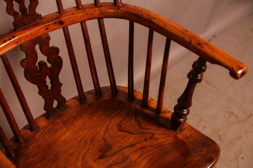 A pair of antique wooden Windsor armchairs featuring pierced splats, spindle backs, and turned legs with rich brown grain. View IX