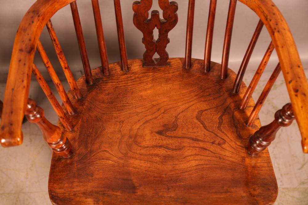 A pair of antique wooden Windsor armchairs featuring pierced splats, spindle backs, and turned legs with rich brown grain. View XIII