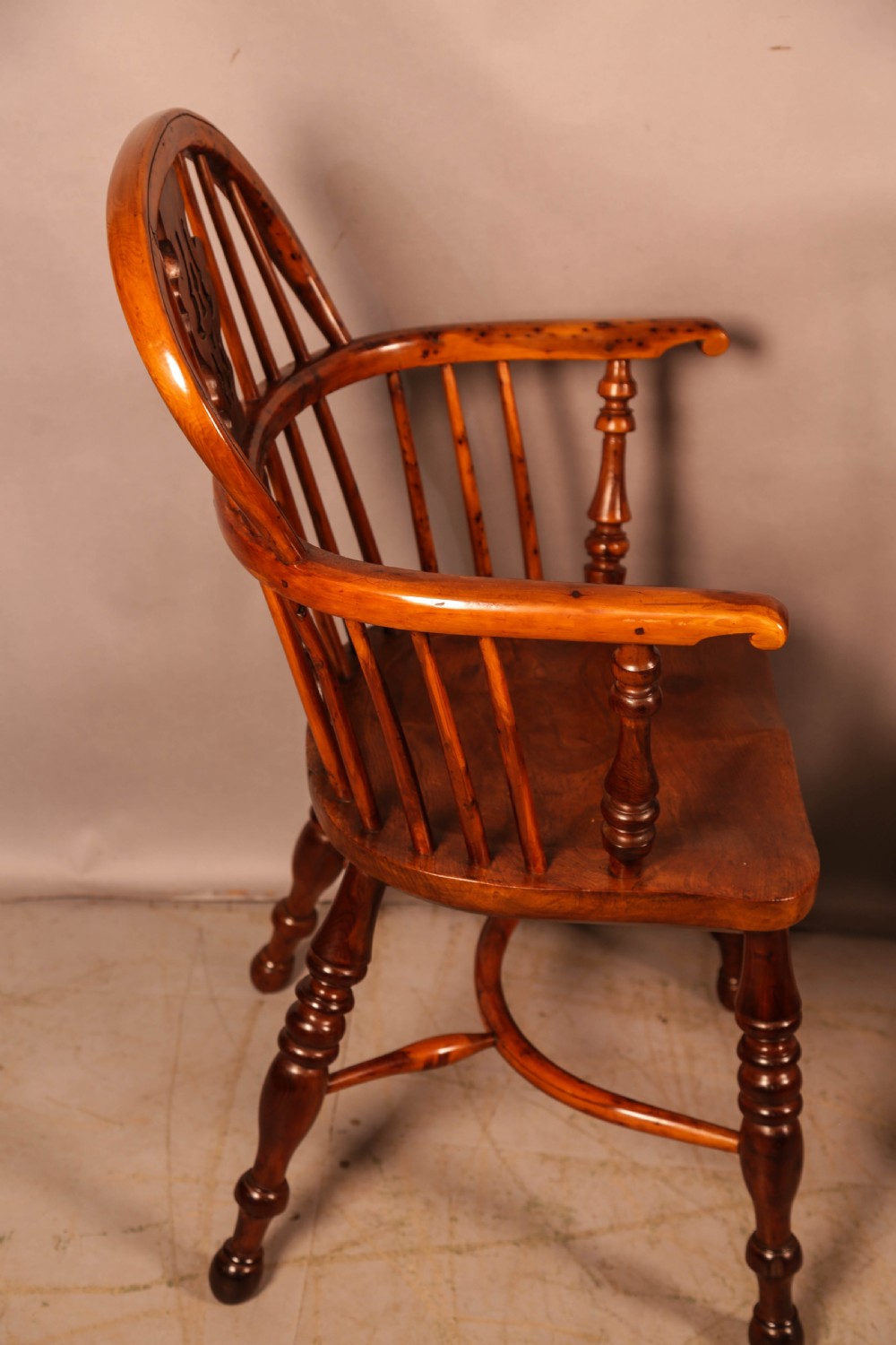 A pair of antique wooden Windsor armchairs featuring pierced splats, spindle backs, and turned legs with rich brown grain. View XIV