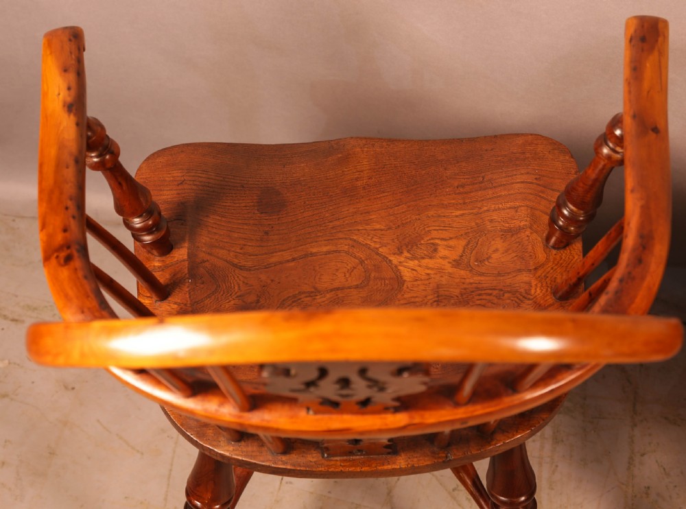A pair of antique wooden Windsor armchairs featuring pierced splats, spindle backs, and turned legs with rich brown grain. View XVI