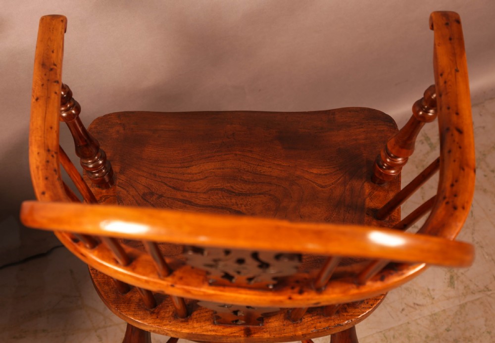 A pair of antique wooden Windsor armchairs featuring pierced splats, spindle backs, and turned legs with rich brown grain. View XVII