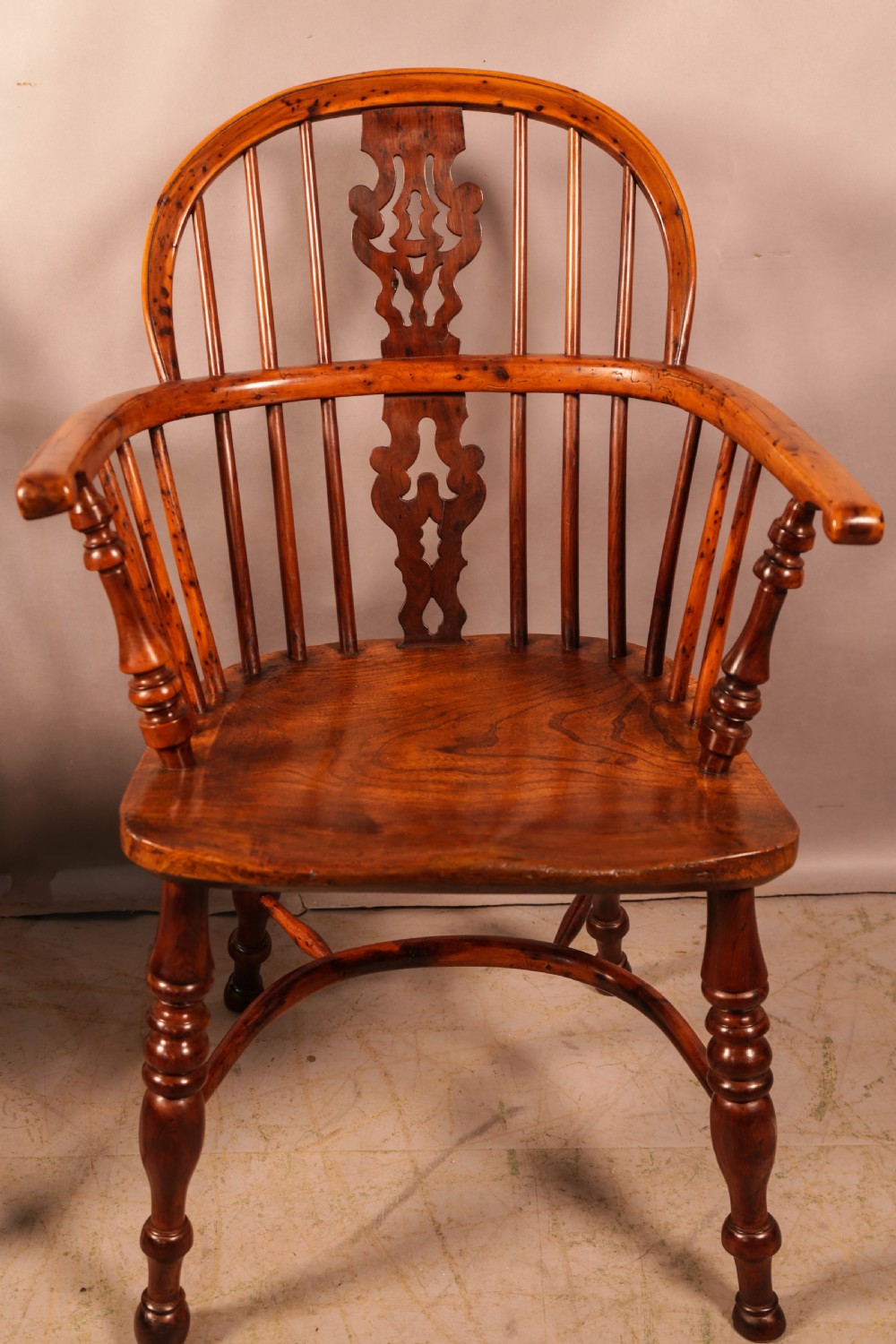 A pair of antique wooden Windsor armchairs featuring pierced splats, spindle backs, and turned legs with rich brown grain. View XVIII