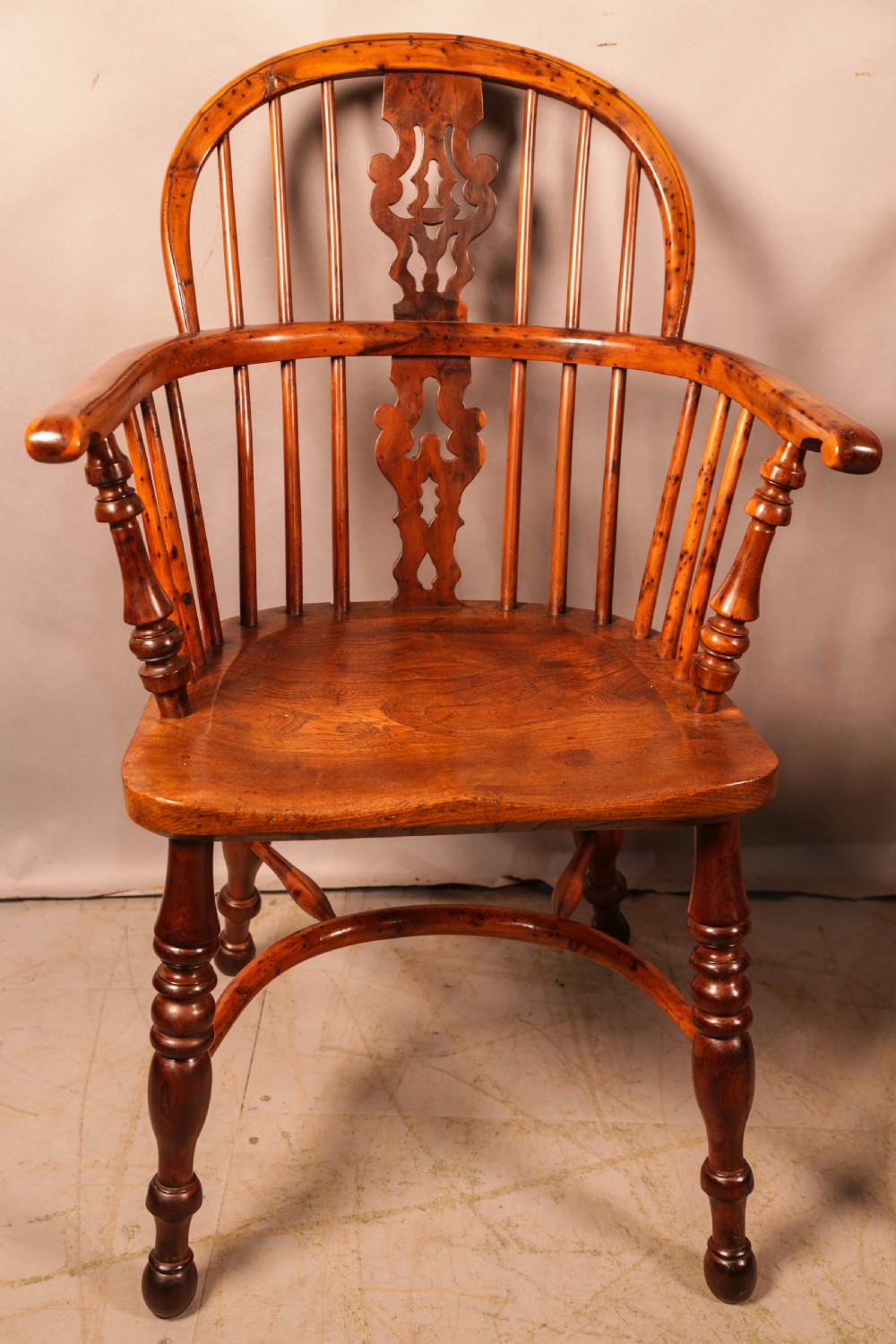 A pair of antique wooden Windsor armchairs featuring pierced splats, spindle backs, and turned legs with rich brown grain. View XIX