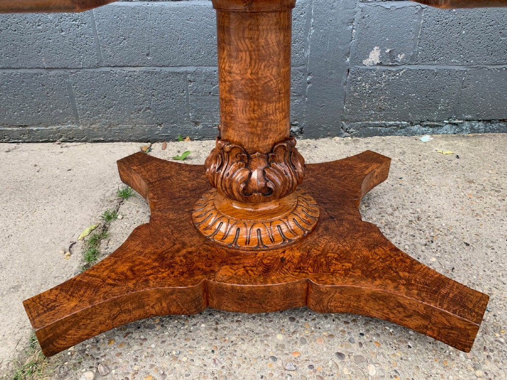 An extended Victorian pollard oak dining table featuring carved columnar legs, a central pedestal base, and a figured wood grain top. View XV