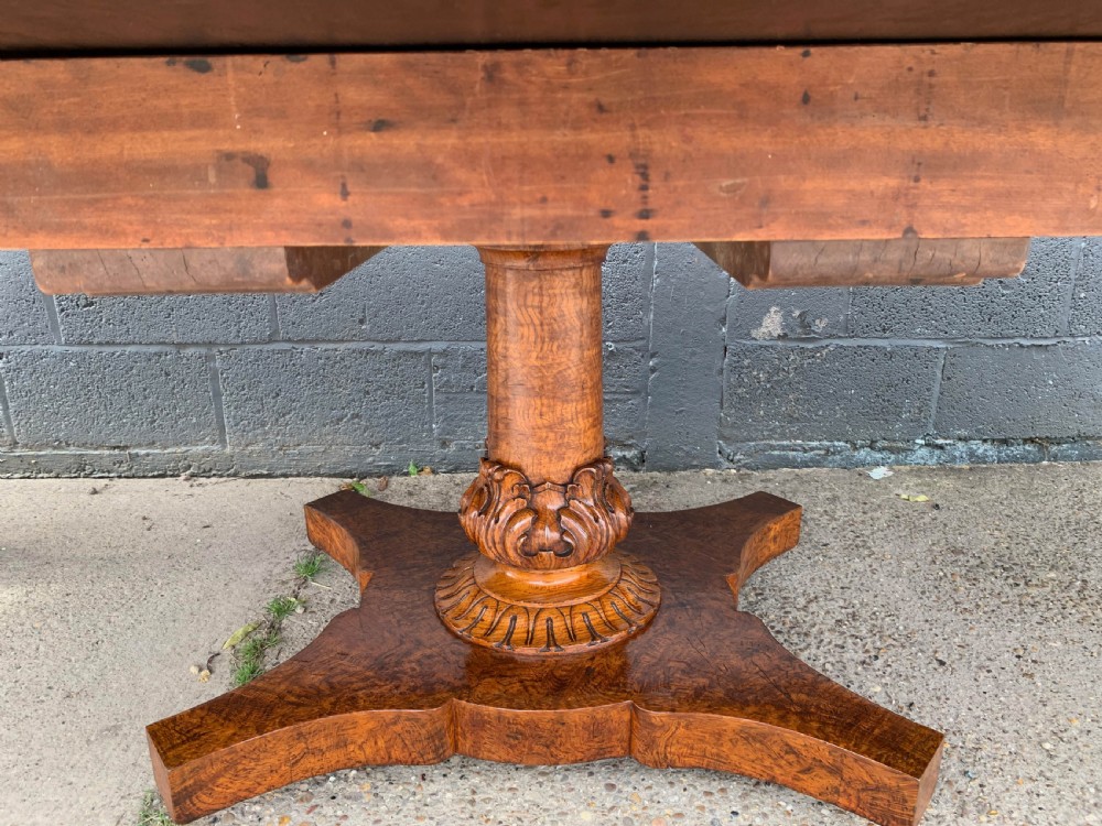 An extended Victorian pollard oak dining table featuring carved columnar legs, a central pedestal base, and a figured wood grain top. View XXII