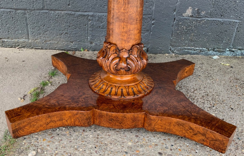 An extended Victorian pollard oak dining table featuring carved columnar legs, a central pedestal base, and a figured wood grain top. View XXIII