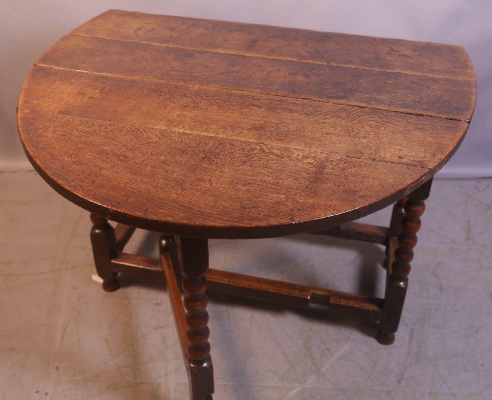 Seventeenth-century oak gateleg table featuring drop-leaf flaps, turned legs, and stretchers. View II
