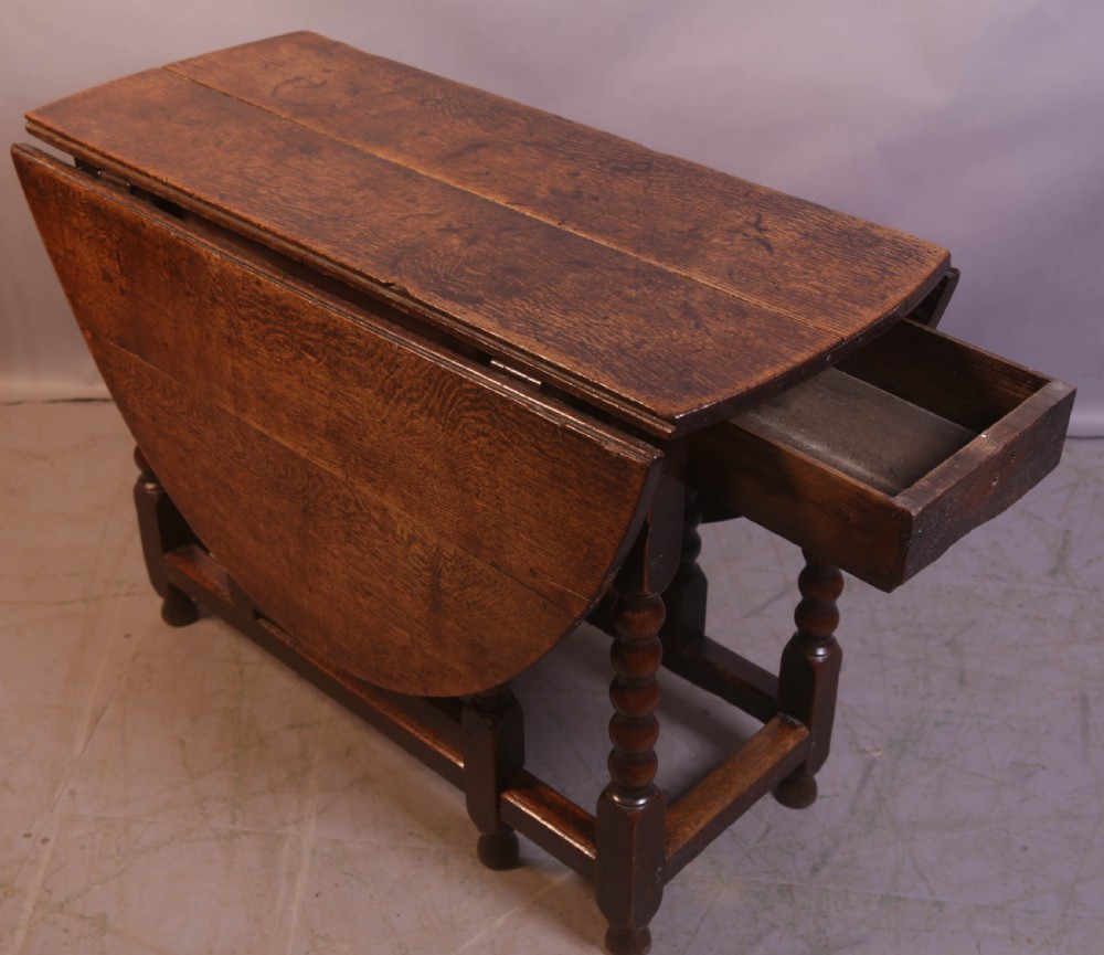 Seventeenth-century oak gateleg table featuring drop-leaf flaps, turned legs, and stretchers. View VI